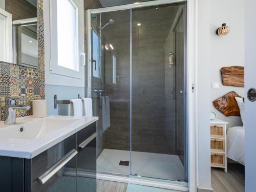 a bathroom with a glass shower and a sink at Villas Pomar do Moinho in Usseira