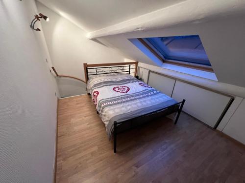 Dormitorio pequeño con cama en el ático en Belle chambre à la frontière Luxembourg, en Audun-le-Tiche