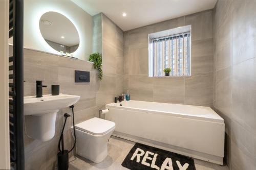 a bathroom with a tub and a toilet and a sink at Luxury Serviced Penthouse - City Centre - En Suite Bedrooms - Free Netflix in Leeds