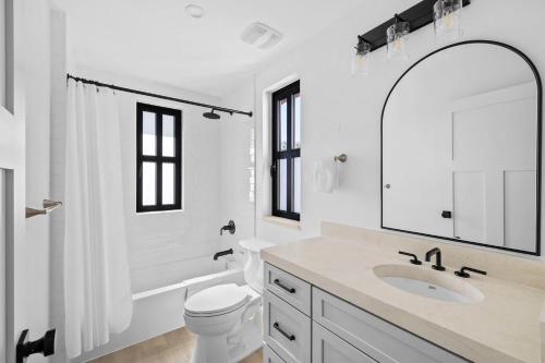 a white bathroom with a sink and a mirror at Las Luces in Spicewood
