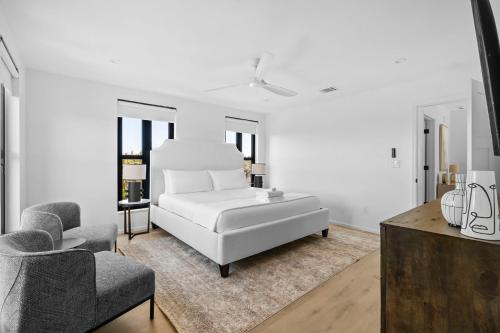 a white living room with a white couch and two chairs at Las Luces in Spicewood