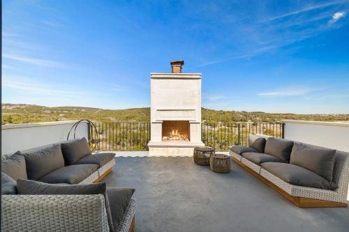 a patio with two couches and a fireplace at Las Luces in Spicewood