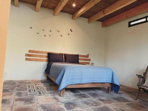 una camera da letto con un letto con uccelli sul muro di CASA LOS OCOTES VALLE DE BRAVO EDO MEX a Valle de Bravo