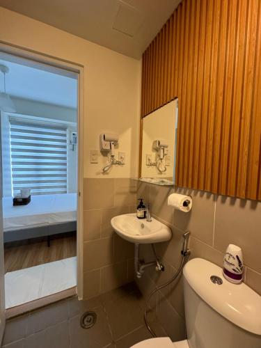 een badkamer met een toilet, een wastafel en een bad bij K&K The Modern Crib in Biñan