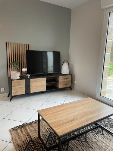 a living room with a flat screen tv on a entertainment center at Villa Ty Loin vue mer 5 personnes in Logonna-Daoulas