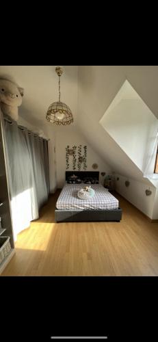 une chambre avec un lit et un lustre dans l'établissement À 5 minutes à pieds du château, 2 belles et spacieuses chambres, SDB, WC et un garage privé à 25 minutes circuit 24h, à Le Grand-Lucé