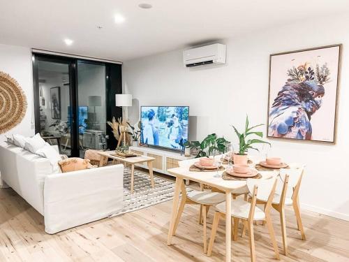 a living room with a table and a white couch at Canberra City - Parking - Self check-in - Pool in Canberra