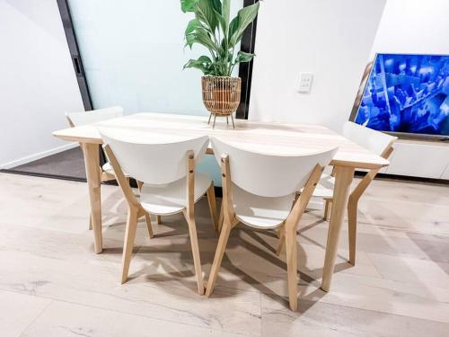 a white table and chairs with a potted plant at City Centre - Pool - Parking - Self check-in in Canberra