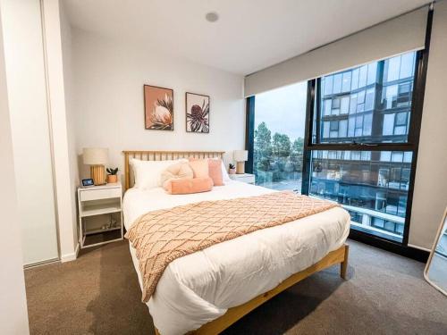 a bedroom with a large bed and a large window at City Centre - Pool - Parking - Self check-in in Canberra