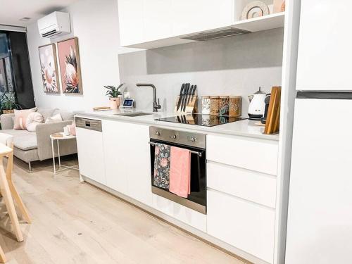 a kitchen with a sink and a stove top oven at City Centre - Pool - Parking - Self check-in in Canberra