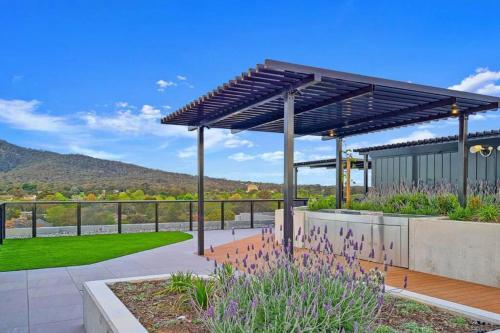 a pergola in a garden with mountains in the background at City Centre - Pool - Parking - Self check-in in Canberra