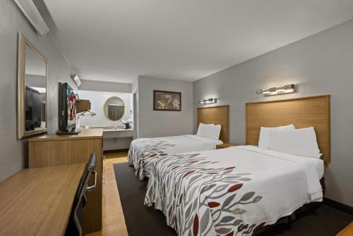 ein Hotelzimmer mit 2 Betten und einem Flachbild-TV in der Unterkunft Red Roof Inn Greensboro Airport in Greensboro