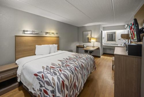 a hotel room with a bed and a desk at Red Roof Inn Greensboro Airport in Greensboro