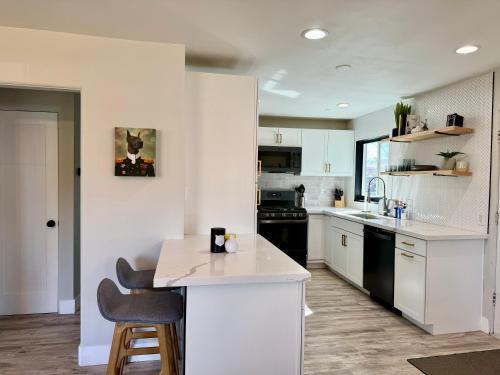 a kitchen with white cabinets and black appliances at Sunshine House in Reno