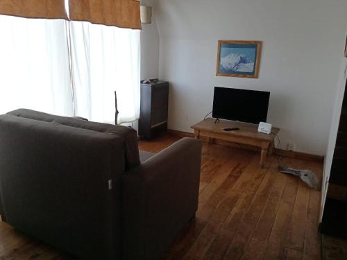 a living room with a couch and a television at Cabaña Ahnen in Ushuaia