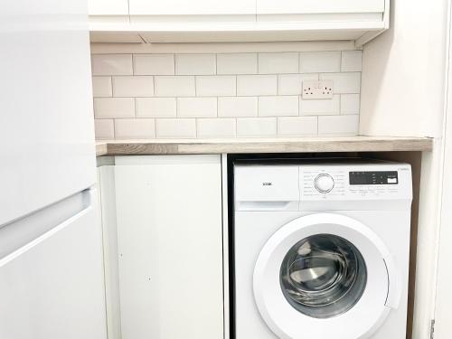 a laundry room with a washer and dryer at Sandringham House Serviced Rooms in Hartlepool
