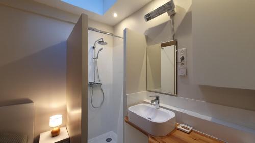 y baño blanco con lavabo y ducha. en Studi'O, en Maisons-Laffitte