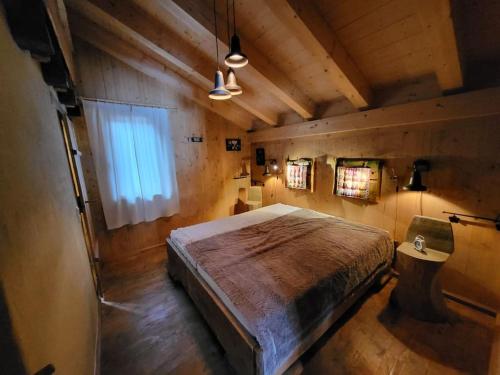 um quarto com uma cama grande e uma janela em Casa Royal - Schönes Blockhaus mit Außensauna und Bade-Bottich em Sankt Englmar