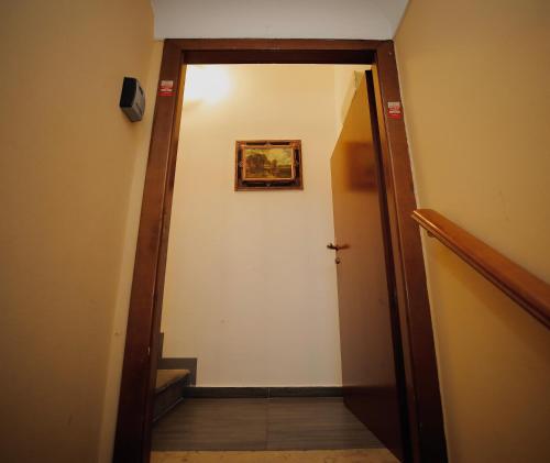 a hallway with a door and a picture on the wall at Hosting Dreams Attics - Duomo in Milan