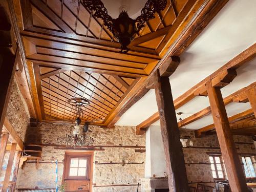 a room with a wooden ceiling and windows at Aristotelous Alexandrou Historic Inn in Arnaia