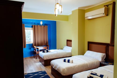 een hotelkamer met 3 bedden en een bureau bij 2Rest in Dahab