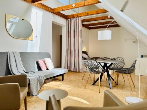 Una sala de estar con un sofá, una mesa y sillas. en ParkSide by BestChoice - Self Check-in with Parking Option, en Graz