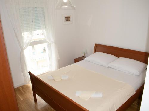 a bedroom with a bed with two white pillows and a window at An apartment M & K - 70 m2 in Ljubuški
