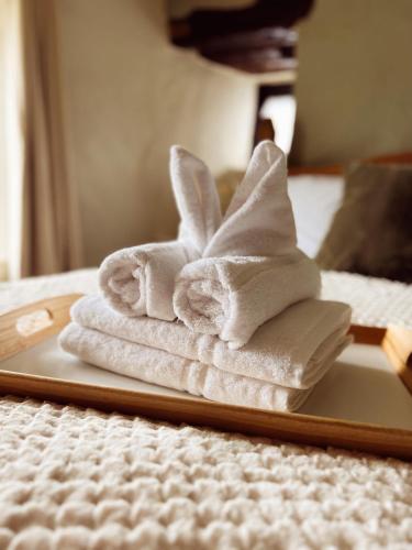 a pile of towels sitting on a tray on a bed at Holly Cottage in Cartmel