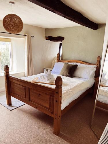 a bedroom with a wooden bed in a room at Holly Cottage in Cartmel