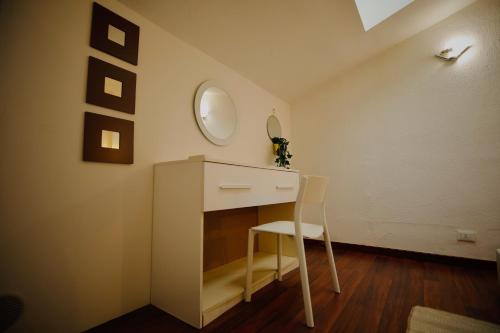 a room with a vanity with a chair and a mirror at Hosting Dreams Attics - Duomo in Milan