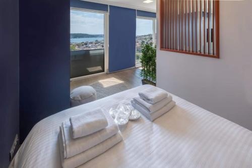 Un dormitorio con una cama blanca con toallas. en 2 Br W Panoramic Bosphorus Views & Cleaning, en Estambul