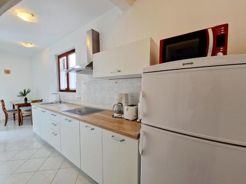 a kitchen with white cabinets and a refrigerator at Villa Aleksandar Porec in Poreč