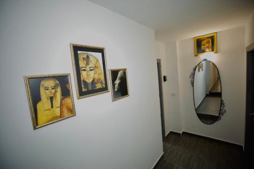 a hallway with pictures on a wall and a mirror at Hosting Dreams Attics - Duomo in Milan