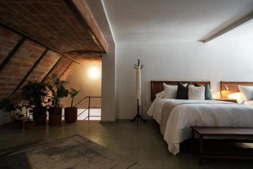 a bedroom with a large bed and plants in it at Hotel Hércules in Querétaro