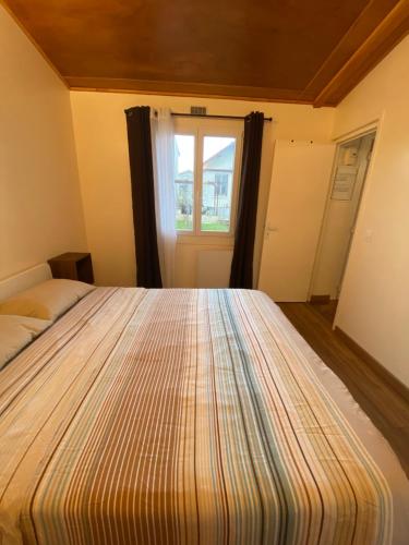 un grand lit dans une chambre avec une fenêtre dans l'établissement Très belle maison neuve F2 avec grand jardin, à Louvres