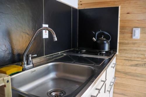 a kitchen with a sink and a kettle on a stove at Casa Profunda - Santa Elena in Medellín