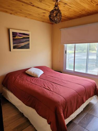 a bedroom with a large red bed with a window at CASA PARA 10 PERSONAS, CAFAYATE in Cafayate