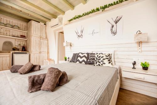 a bedroom with a large white bed with furry pillows at Opus studio in Agios Stefanos