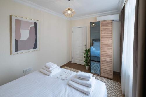 una camera da letto con un letto bianco e asciugamani di Modern Space Walking Distance From Taksim Sq a Istanbul