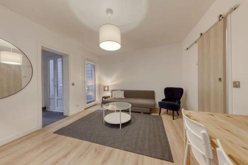 un salon avec une table et un canapé dans l'établissement *Le Chic* Proche Paris JO 2024, à Clichy