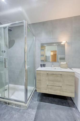 une salle de bain avec une douche, un lavabo et un miroir dans l'établissement *Le Chic* Proche Paris JO 2024, à Clichy