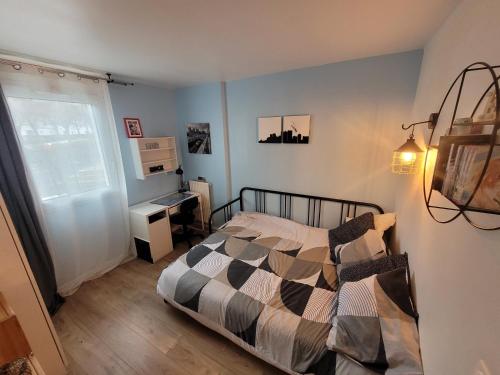 um quarto com uma cama, uma secretária e uma janela em APPARTEMENT AGREABLE PROCHE DES SITES JO 2024 em Élancourt