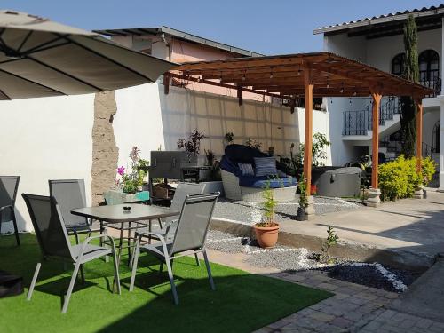 a patio with a table and chairs and an umbrella at Blue Moon Hostel in Antigua Guatemala
