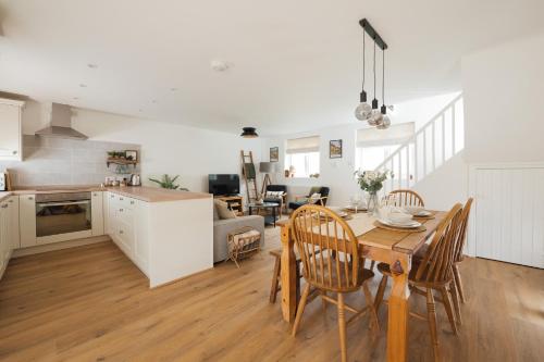 a kitchen and living room with a table and chairs at Cosy Cotswolds Getaway - Stow-on-the-Wold - Eagle Cottage in Wyck Rissington