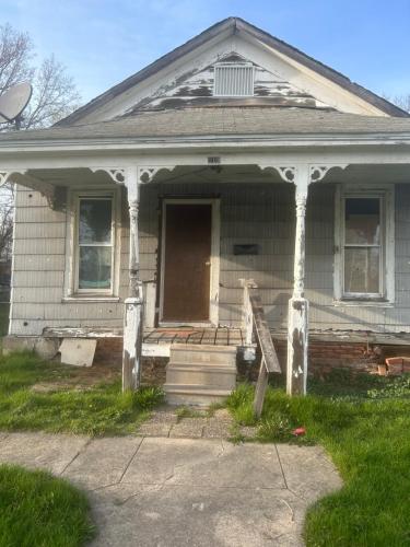 an old house with a porch and a door at Leah Bungalow in Lincoln