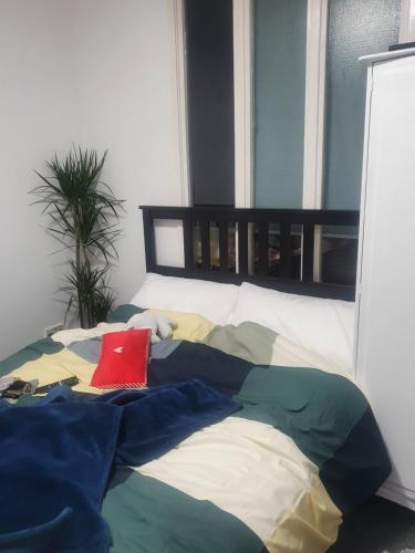 a bed with a red pillow on top of it at Queensgate centre in Stifford