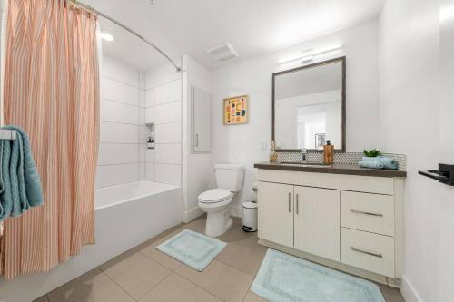 een badkamer met een wastafel, een toilet en een spiegel bij Sky-High Elegance WaterFront Penthouse 4 Beds in Los Angeles