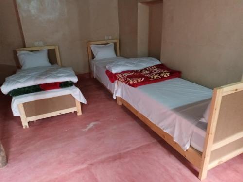 2 Einzelbetten in einem Zimmer mit rosa Böden in der Unterkunft Ecolodge Espace Tamount in Demnate