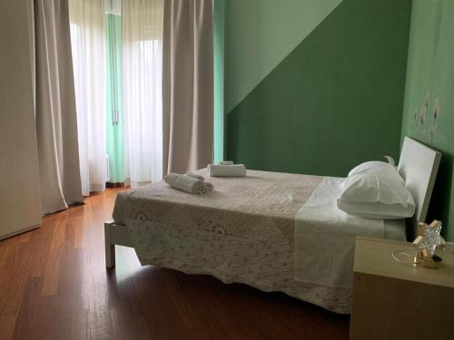sypialnia z łóżkiem i zieloną ścianą w obiekcie Casa di Bea w mieście Merate