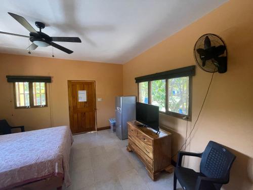 a bedroom with a bed and a flat screen tv at R&V VILLA in Negril